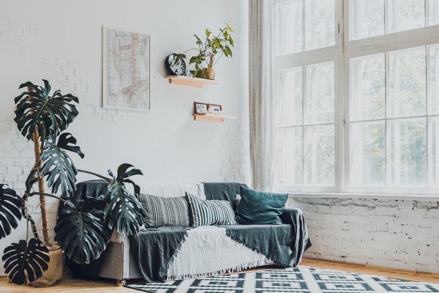 Bright, freshly cleaned living room with large windows and a green sofa